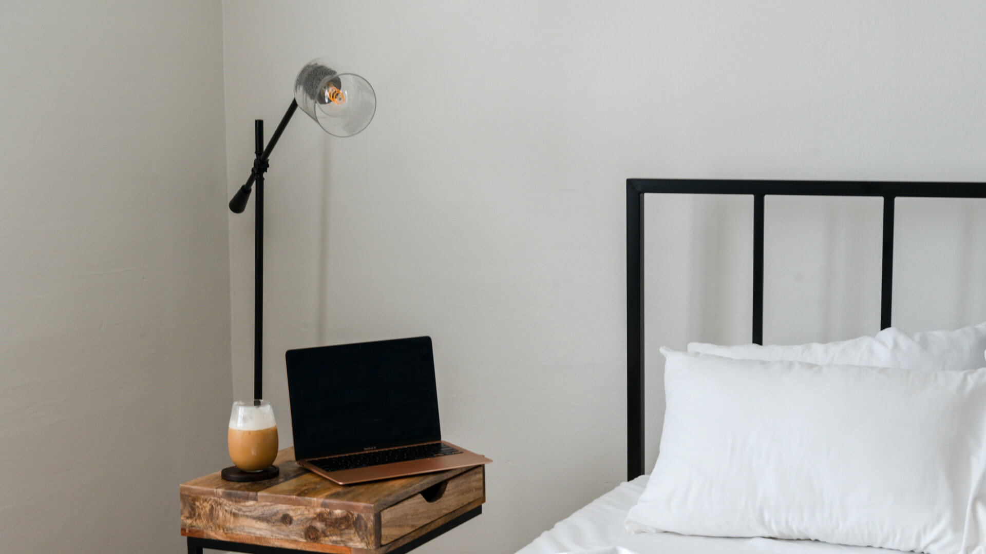 a bed with a laptop on it and a lamp at The Arlington Park Apartments