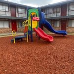 a playground with a slide and a slide at The Arlington Park Apartments
