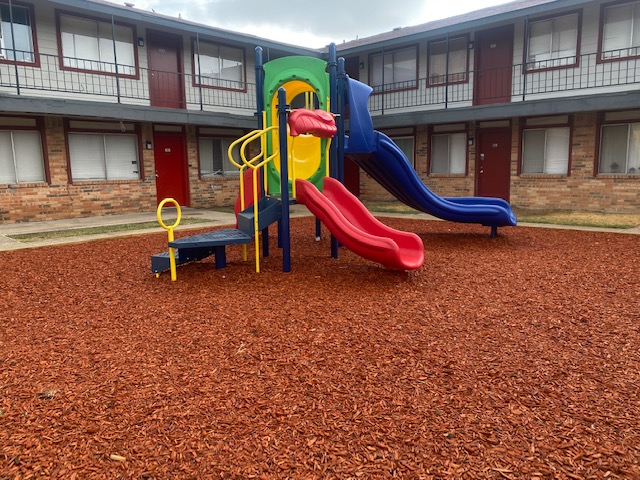 a playground with a slide and a slide at The Arlington Park Apartments