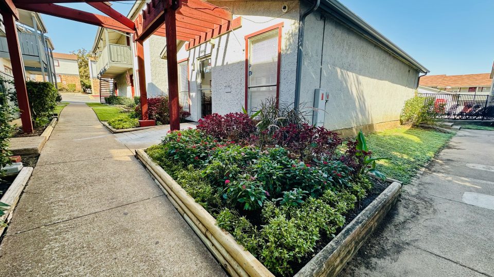 the front yard of a house with a garden and a walkway at The Arlington Park Apartments